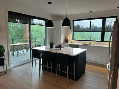 a kitchen with a island with black and white counter tops at Le Joford in Orford