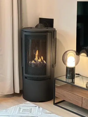 a fireplace in a living room with a fire in it at Le Joford in Orford