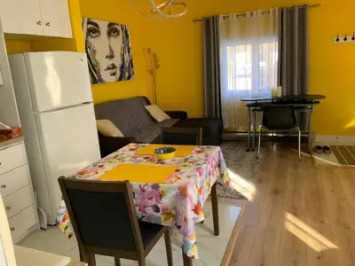 a kitchen and living room with a table and a dining room at Maisonnette dans la nature en pleine ville. in Trois-Rivières