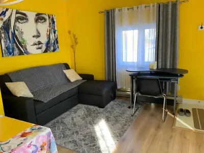a living room with a couch and a table at Maisonnette dans la nature en pleine ville. in Trois-Rivières