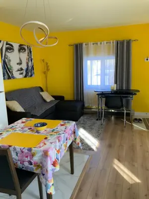 a living room with a table and a piano at Maisonnette dans la nature en pleine ville. in Trois-Rivières