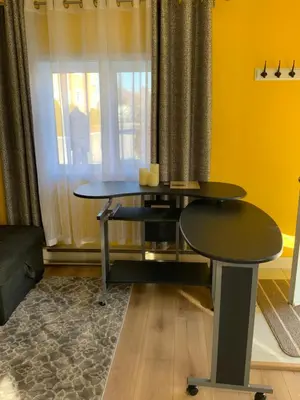 a table and two stools in a room with a window at Maisonnette dans la nature en pleine ville. in Trois-Rivières