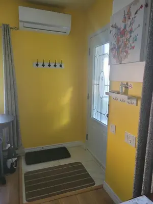 a room with a yellow wall and a door at Maisonnette dans la nature en pleine ville. in Trois-Rivières