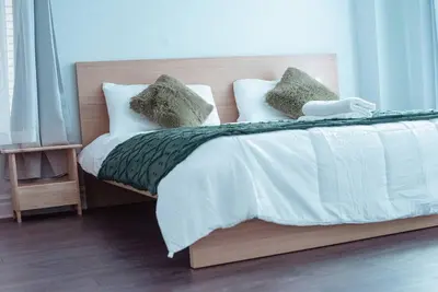 a bed with white sheets and green pillows at Spacieux Appartement de 3 Chambres downtown in Montréal