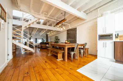 a kitchen and dining room with a wooden table and chairs at North House - Stunning Old Montreal Penthouse in Montréal