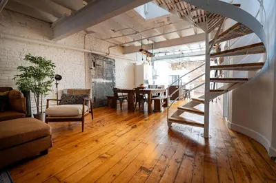a living room with a spiral staircase and a table at North House - Stunning Old Montreal Penthouse in Montréal