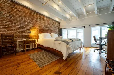 a bedroom with a brick wall and a bed at North House - Stunning Old Montreal Penthouse in Montréal