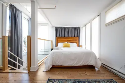 a bedroom with a bed and a large window at North House - Stunning Old Montreal Penthouse in Montréal