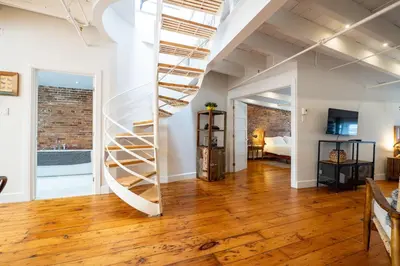 a living room with a spiral staircase in a loft at North House - Stunning Old Montreal Penthouse in Montréal