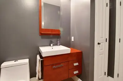 a bathroom with a sink and a toilet and a mirror at LeChamplain #206 CITQ#248275 in Bromont