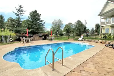 a swimming pool in a yard with a table and chairs at LeChamplain #206 CITQ#248275 in Bromont