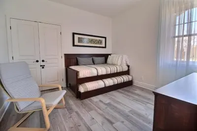 a room with a bed and a chair and a window at LeChamplain #206 CITQ#248275 in Bromont