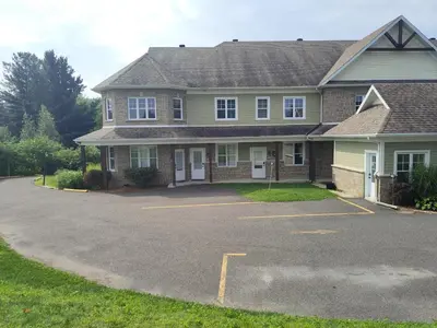 a house with a parking lot in front of it at LeChamplain #206 CITQ#248275 in Bromont