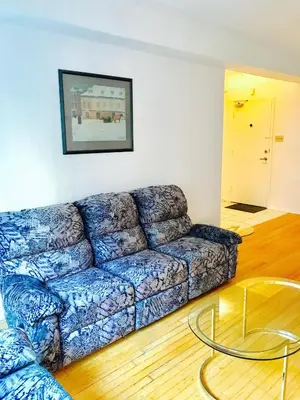 a blue couch in a living room with a glass table at Stylish Montreal Apartment: Comfortable Stay in the Golden Square Mile in Montréal