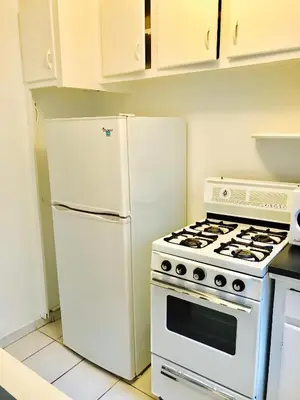 a kitchen with a white stove and a refrigerator at Stylish Montreal Apartment: Comfortable Stay in the Golden Square Mile in Montréal