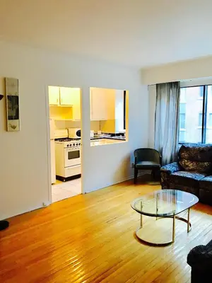 a living room with a couch and a glass table at Stylish Montreal Apartment: Comfortable Stay in the Golden Square Mile in Montréal