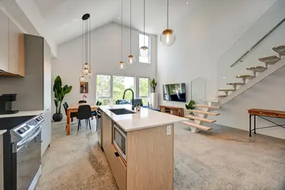 an open kitchen and living room with a staircase at Luxury Penthouse 3BR 2BR Downtown Private Roof Terrace presented by TripMontreal in Montréal