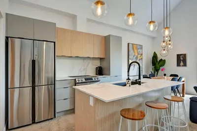a kitchen with a stainless steel refrigerator and cabinets at Luxury Penthouse 3BR 2BR Downtown Private Roof Terrace presented by TripMontreal in Montréal