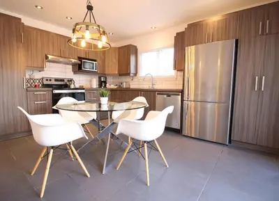 a kitchen with a glass table and white chairs at Luxueux - Deco moderne, Rosemont in Montréal