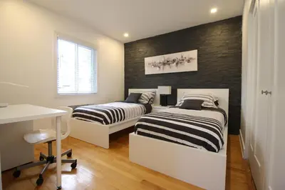 a bedroom with two beds and a desk in it at Luxueux - Deco moderne, Rosemont in Montréal