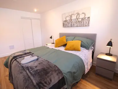 a bedroom with a bed with green sheets and yellow pillows at Luxueux - Deco moderne, Rosemont in Montréal