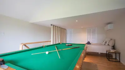 a green pool table in a room with a bed at Chalet BIA - Cap au Sud in Trois-Lacs