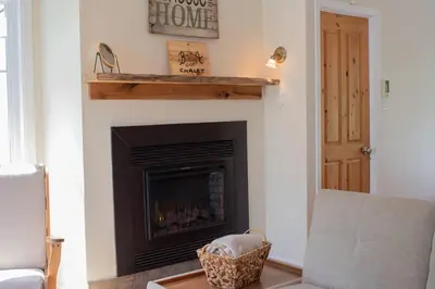 a living room with a fireplace with a fire place at Chalet BIA - Cap au Sud in Trois-Lacs