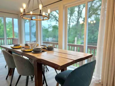 a dining room table with chairs and a chandelier at Chalet BIA - Au courant des 2 rivières in Weedon-Centre