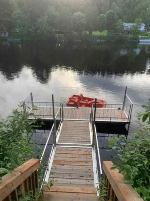 a dock with a red boat on the water at Chalet BIA - Au courant des 2 rivières in Weedon-Centre