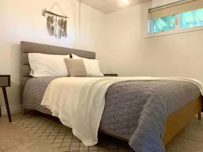 a bedroom with a bed with a blanket and a window at Chalet BIA - Au courant des 2 rivières in Weedon-Centre