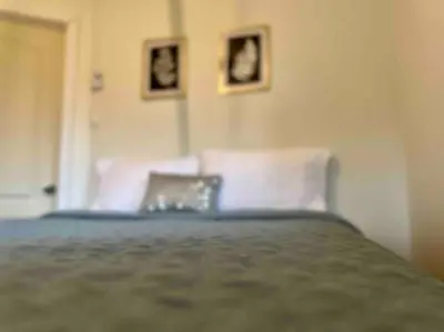 a bedroom with a bed and two pictures on the wall at Chalet BIA - Au courant des 2 rivières in Weedon-Centre