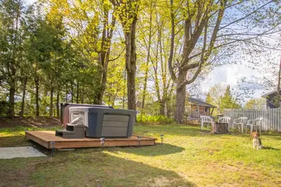 a trailer sitting on a deck in a yard with a dog at Chalet BIA Foyer & Spa in Trois-Lacs