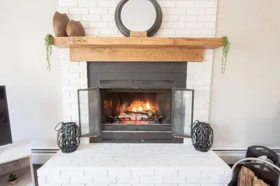 a fireplace with a mirror on top of it at Chalet BIA Foyer & Spa in Trois-Lacs