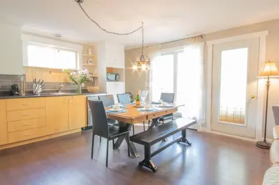 a kitchen with a dining room table with chairs at Chalet BIA Foyer & Spa in Trois-Lacs
