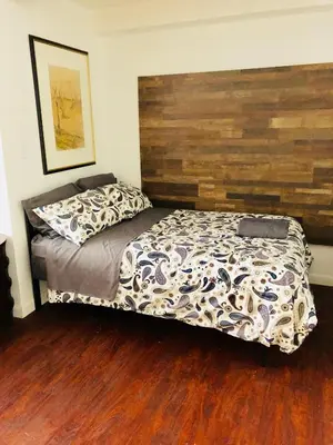 a bedroom with a bed with a wooden headboard at Stylish Montreal Apartment: Comfortable Stay in the Golden Square Mile in Montréal