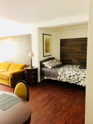 a hotel room with two beds and a couch at Stylish Montreal Apartment: Comfortable Stay in the Golden Square Mile in Montréal