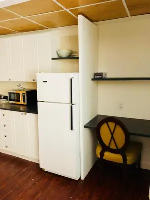 a kitchen with a white refrigerator and a chair at Stylish Montreal Apartment: Comfortable Stay in the Golden Square Mile in Montréal
