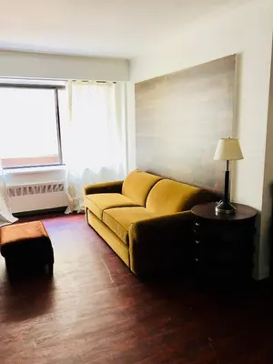 a yellow couch in a living room with a window at Stylish Montreal Apartment: Comfortable Stay in the Golden Square Mile in Montréal
