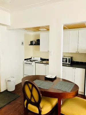 a small kitchen with a wooden table and chairs at Stylish Montreal Apartment: Comfortable Stay in the Golden Square Mile in Montréal