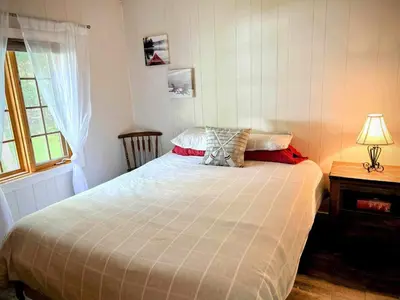 a bedroom with a bed and a window at Chalet Le Shack O2 in Stratford