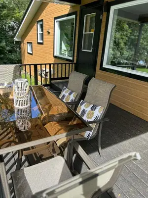 a table and chairs on a deck with a house at Chalet Le Shack O2 in Stratford