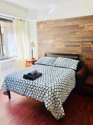 a bedroom with a bed with a black hat on it at Stylish Montreal Apartment: Comfortable Stay in the Golden Square Mile in Montréal