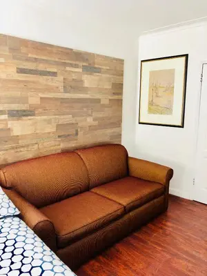 a brown couch in a room with a wooden wall at Stylish Montreal Apartment: Comfortable Stay in the Golden Square Mile in Montréal