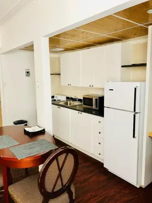 a kitchen with a table and a white refrigerator at Stylish Montreal Apartment: Comfortable Stay in the Golden Square Mile in Montréal
