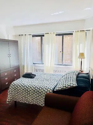 a bedroom with a bed and two windows at Stylish Montreal Apartment: Comfortable Stay in the Golden Square Mile in Montréal