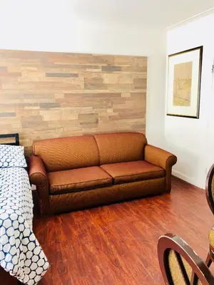 a living room with a brown couch and a wooden floor at Stylish Montreal Apartment: Comfortable Stay in the Golden Square Mile in Montréal