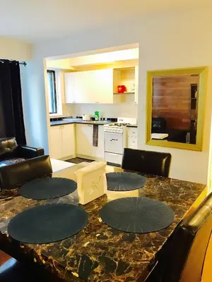 a kitchen and living room with a large marble table at Stylish Montreal Apartment: Comfortable Stay in the Golden Square Mile in Montréal
