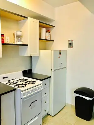 a kitchen with a white stove and a refrigerator at Stylish Montreal Apartment: Comfortable Stay in the Golden Square Mile in Montréal
