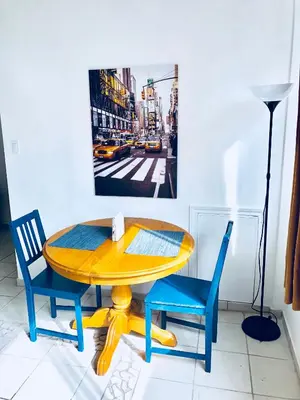 a yellow table with two chairs and a picture on the wall at Stylish Montreal Apartment: Comfortable Stay in the Golden Square Mile in Montréal