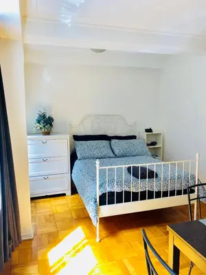 a bedroom with a bed and a dresser and a table at Stylish Montreal Apartment: Comfortable Stay in the Golden Square Mile in Montréal